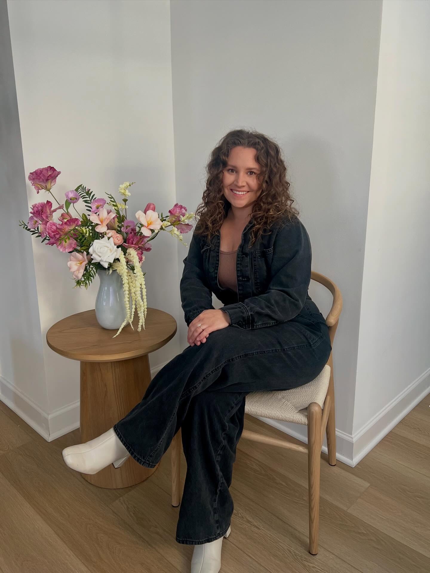 Jade, owner and lead designer of Eternal Blooms & Co., seated beside one of her arrangements